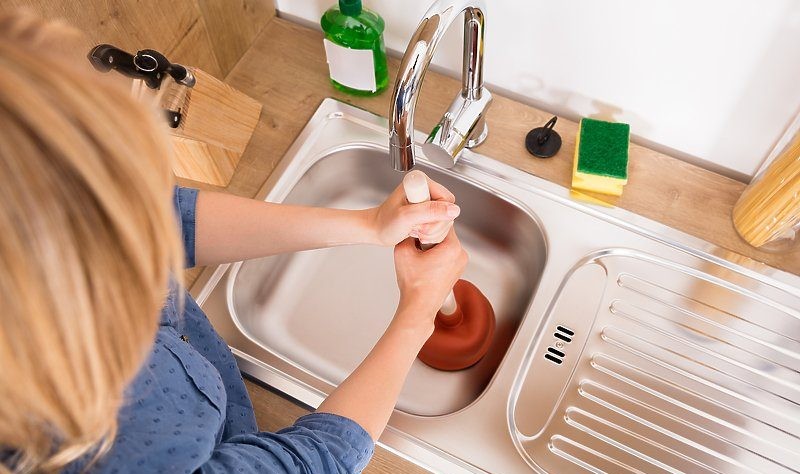 cropped picture of a woman trying to open a drain
