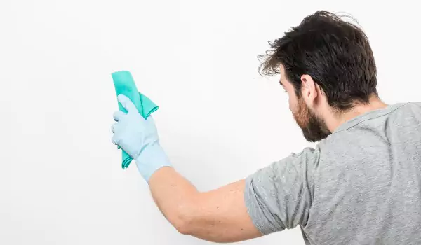 young man cleaning a painted wall