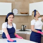 Cleaning service team at work in kitchen in private home