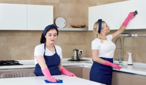 Cleaning service team at work in kitchen in private home