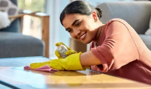 Woman wipe table and spray with cloth for hygiene and home cleaning service for bacteria dust on furniture
